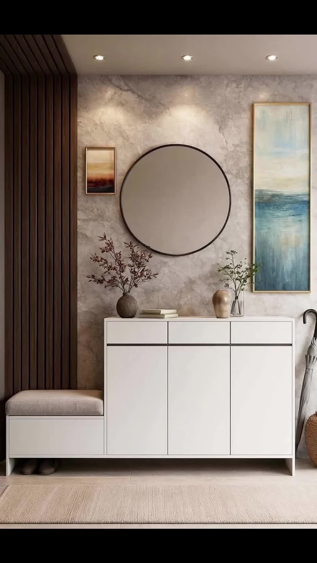 Modern Entryway With White Cabinetry, Marble Wall, and Round Mirror