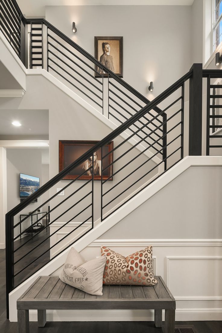 Modern Staircase with Black Metal Railings and Neutral Decor
