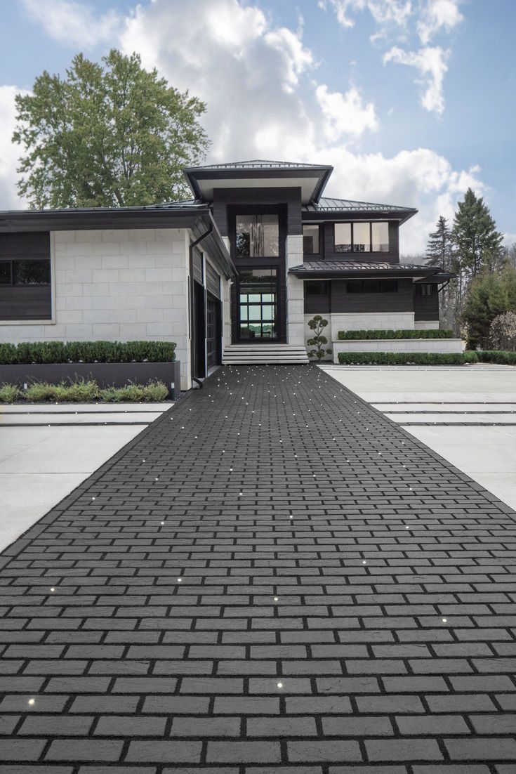 Modern Home with Sleek Brick Driveway and Black Accents