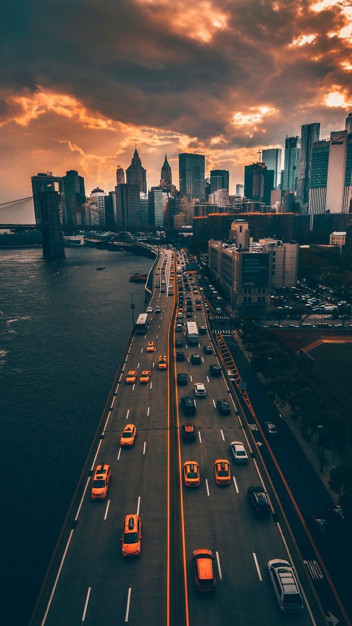 Dramatic City Skyline and Riverfront Highway at Sunset